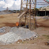 Workers descending into the La Navidad Shaft; note the pre-sorted ore rock in the foreground